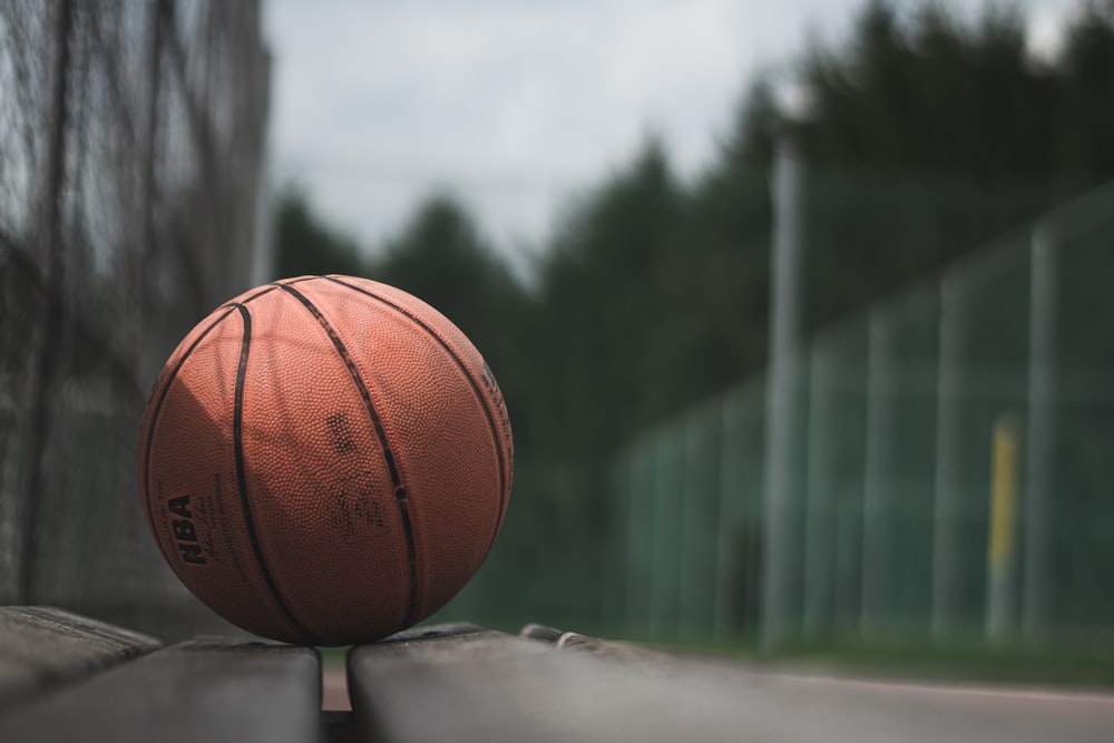 fotografia macro da bola de basquete marrom da NBA em superfície de concreto