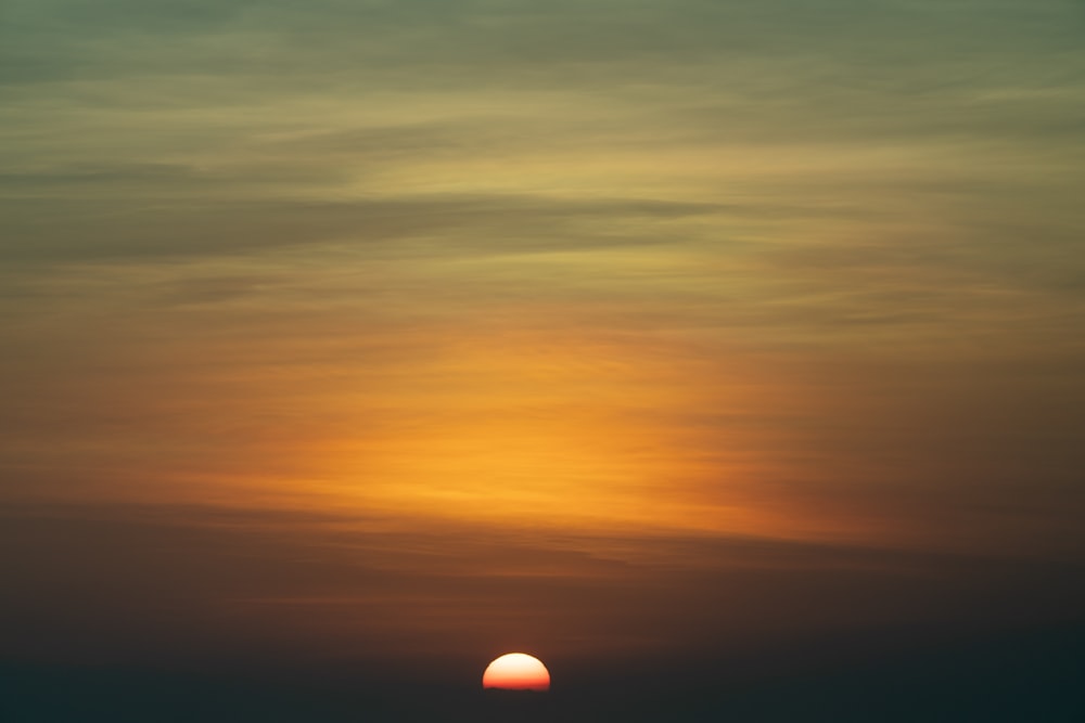 the sun is setting over the horizon of the ocean