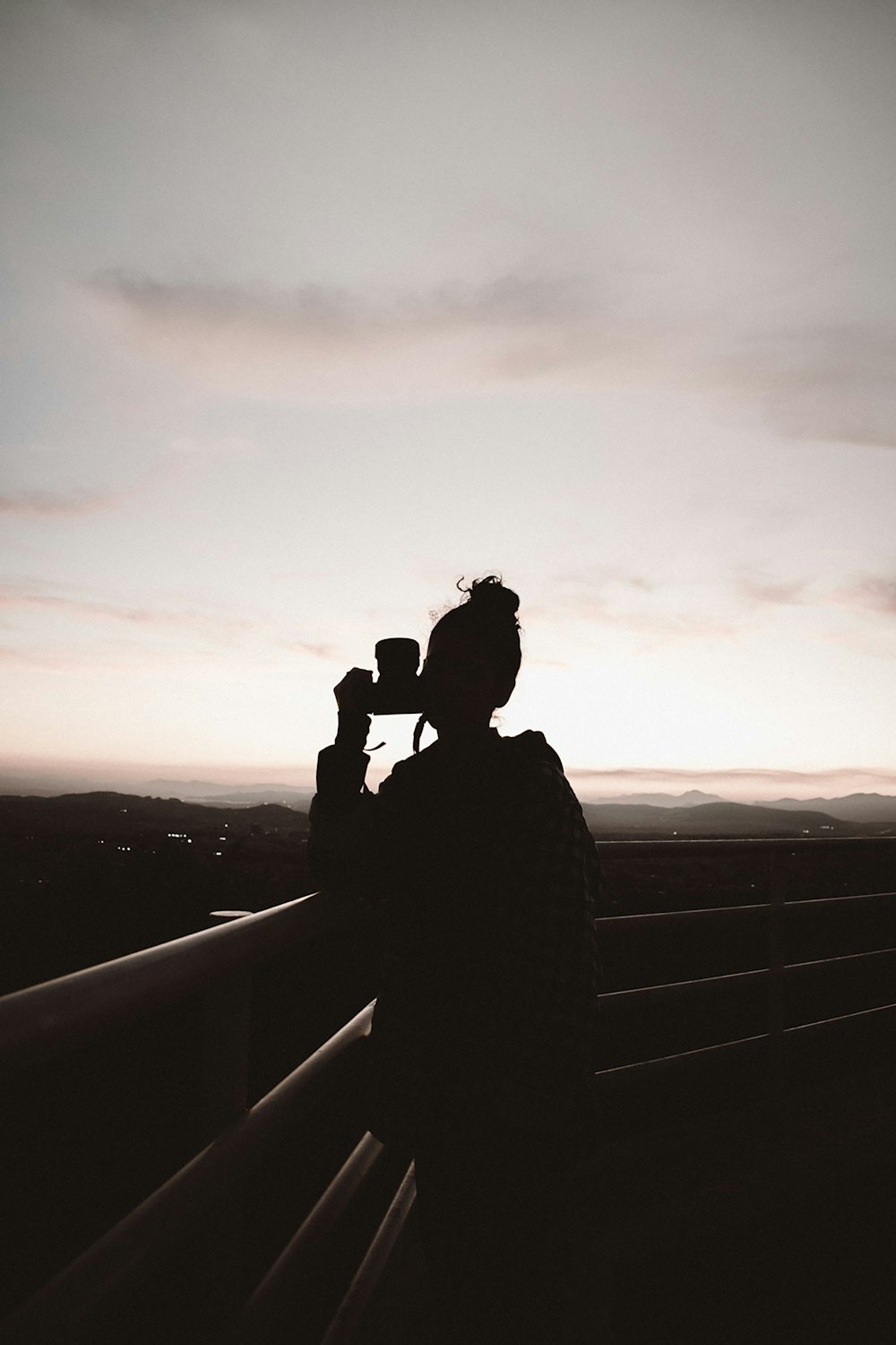 silhouette of person standing and holding camera