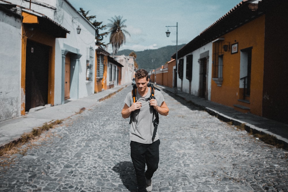 one unknown celebrity in gray shirt walking between houses