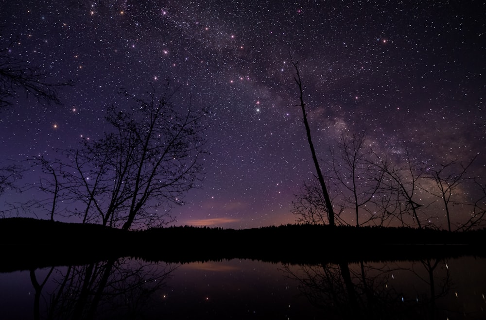 夜の山のシルエットの横の湖