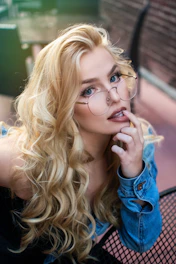 woman wearing eyeglasses with finger on her lip