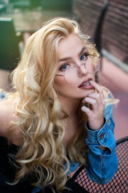 woman wearing eyeglasses with finger on her lip