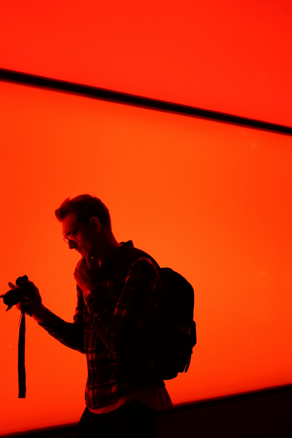 silhouette photography of man holding camera