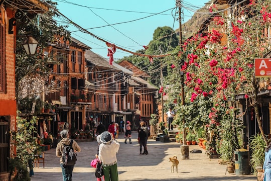 group of people walking near concrete buildings during daytime in Bandipur Nepal