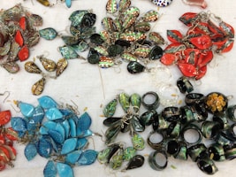 A collection of colorful macramé earrings displayed on a natural linen fabric backdrop