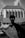 A silhouette of a human-like figure with hollow eyes and an open mouth stands prominently in the foreground, adding a mysterious and eerie vibe. In the background, there is a blurred image of a large, Gothic architectural structure, possibly a church, with pointed arches and a steep roof under a cloudy sky.