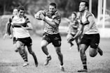 grayscale photography of men playing rugby
