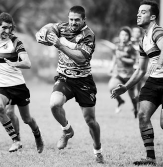 grayscale photography of men playing rugby