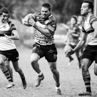 grayscale photography of men playing rugby