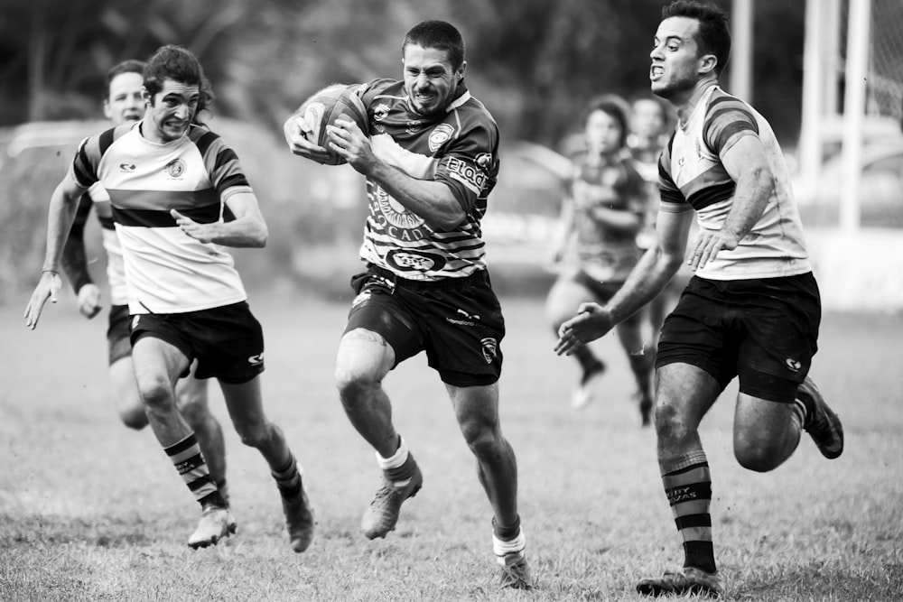 Photographie en niveaux de gris d’hommes jouant au rugby