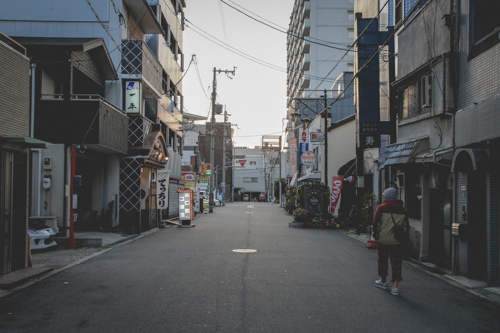 person walking between two buildings