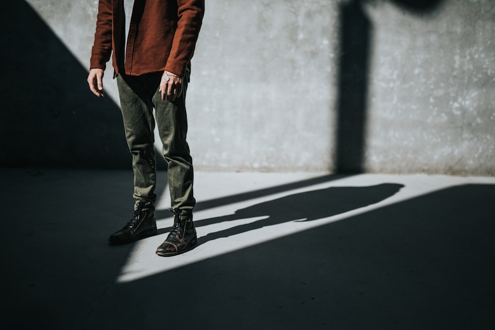 person standing near wall producing shadow