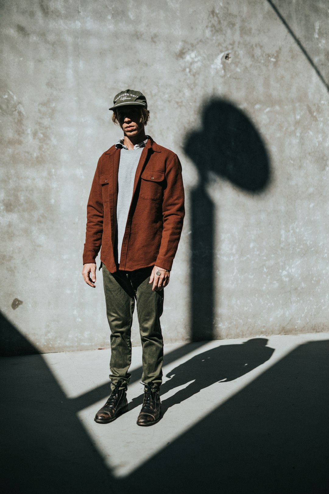 man stands near concrete wall with shadow