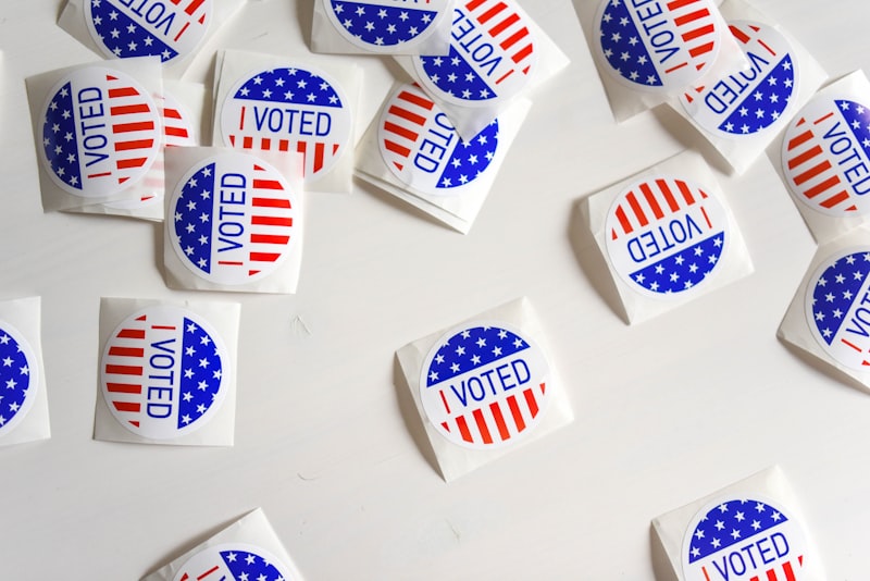 Scattered I Voted stickers with US flag design on a white surface