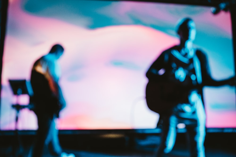 two men playing musical instrument on stage