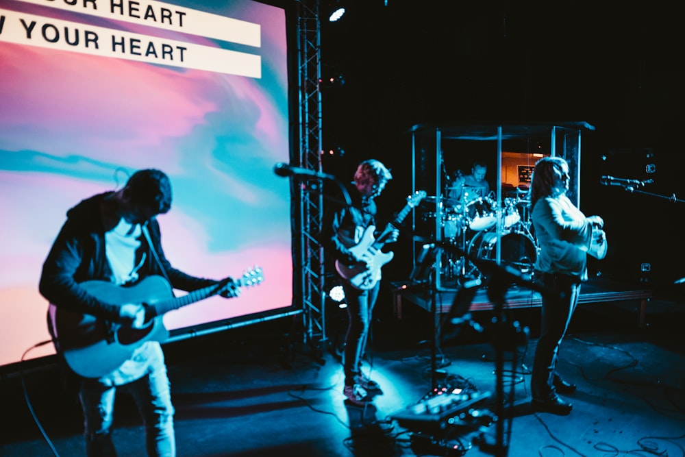 three musicians playing on stage