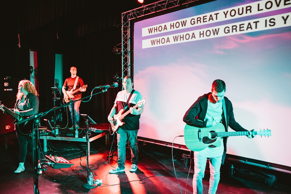 four men band performing on stage