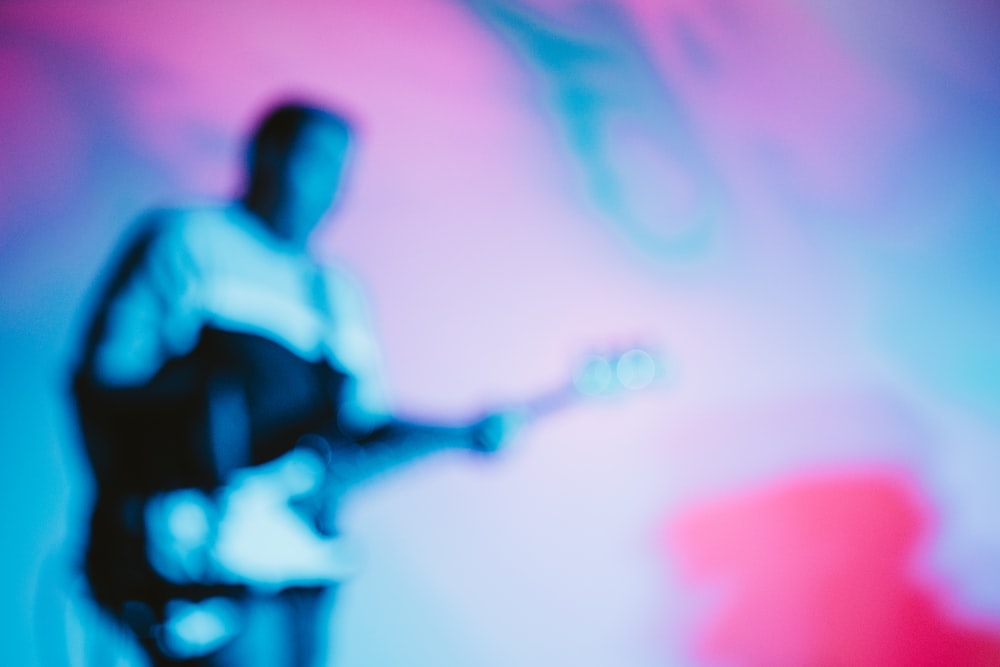 a blurry image of a man playing a guitar