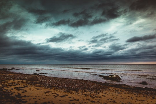 wavy seashore under grey clouds in Užava parish Latvia