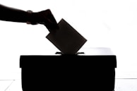 a person is casting a vote into a box