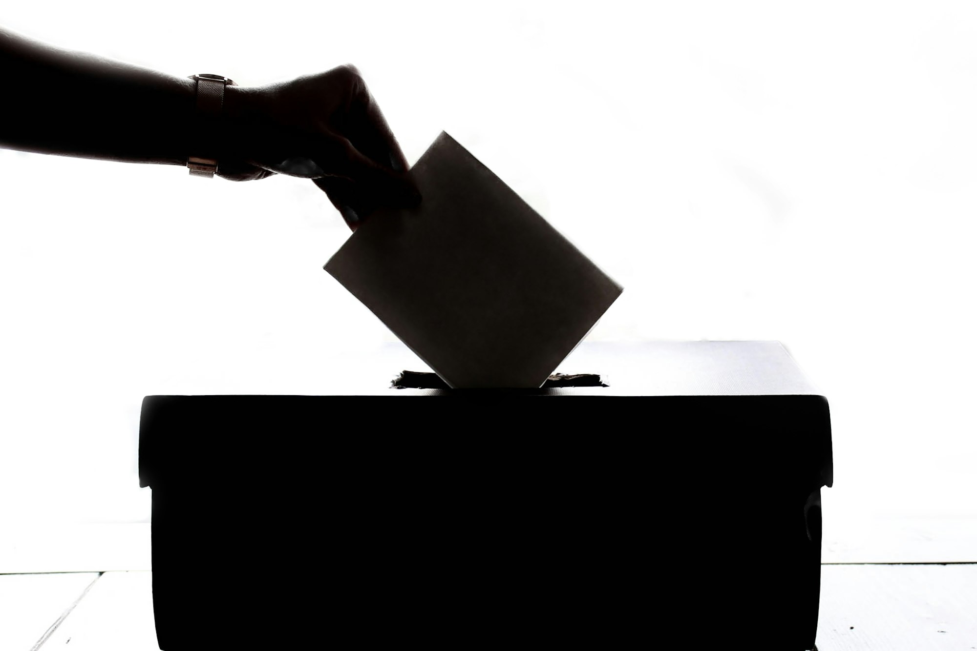 A person's arm putting ballot into ballot box