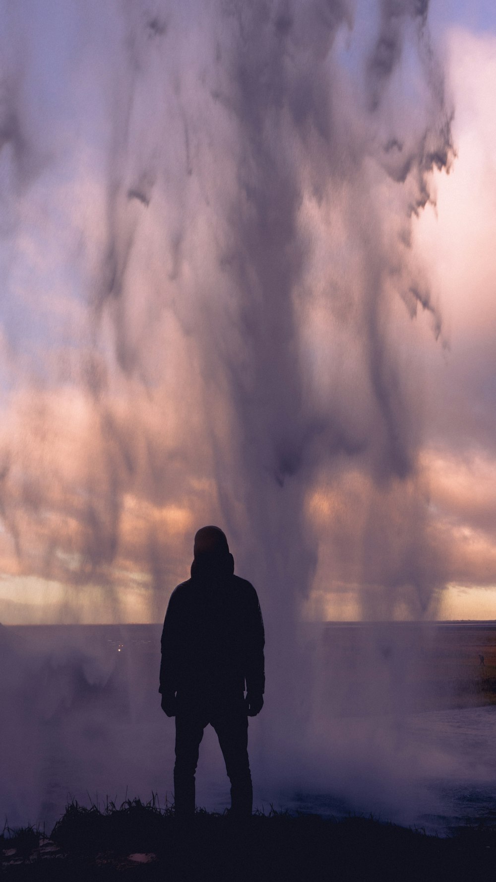 silhouette of person standing near cliff