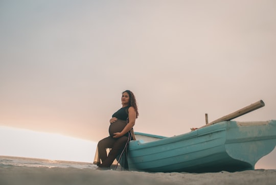 pregnant woman sitting on boat under white clouds in Lima Peru