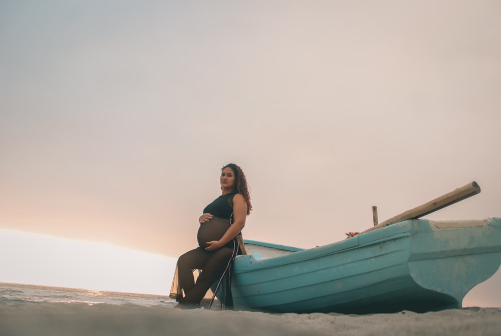 pregnant woman sitting on boat under white clouds