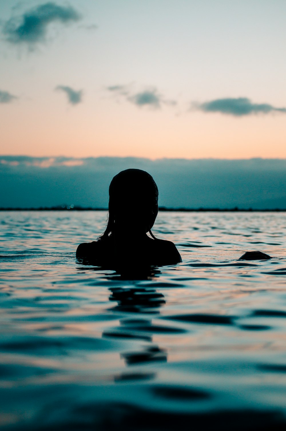 silhouette of woman in body of water