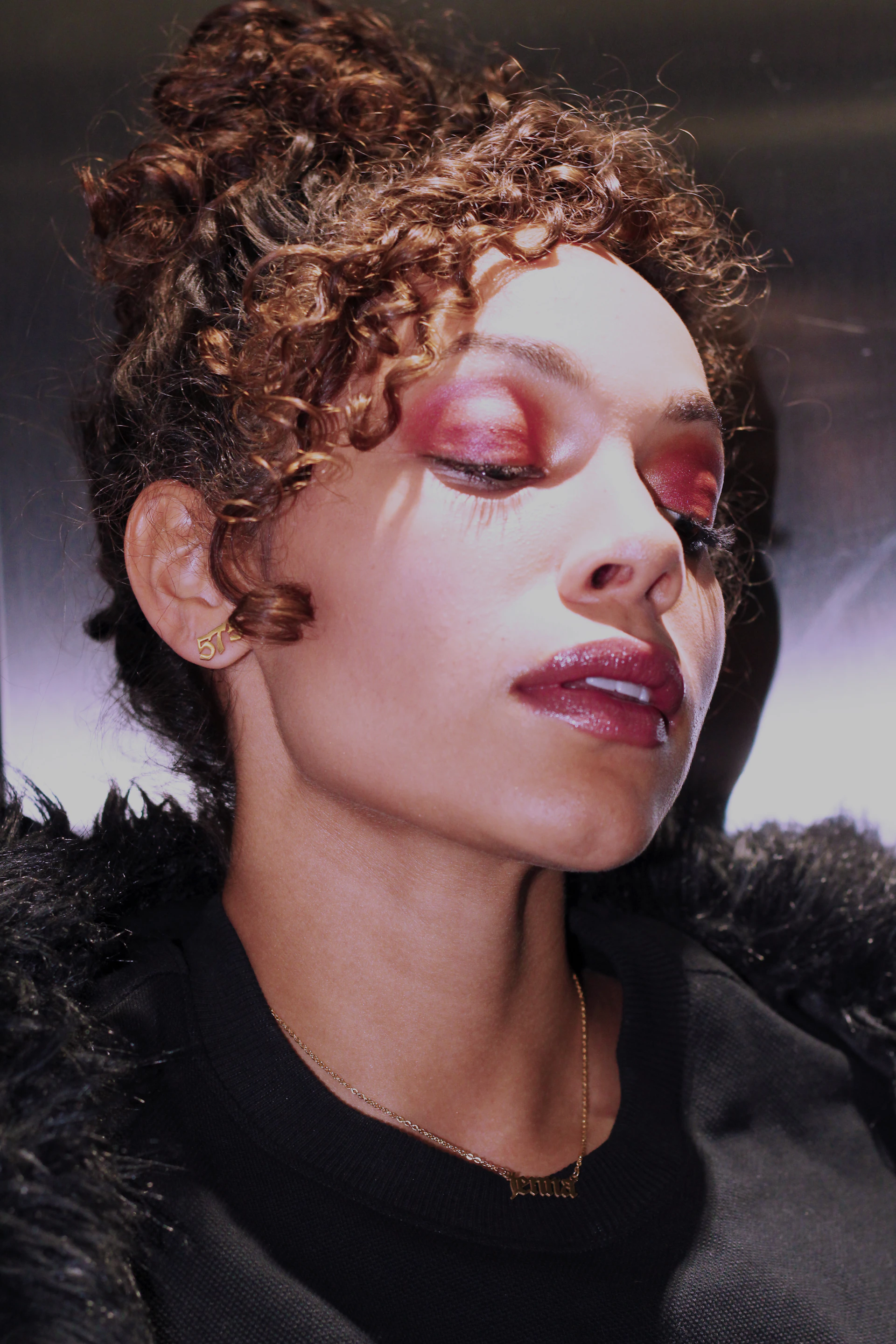 A vibrant full glam makeup style highlighted by bold eyes and glossy lips, complemented by voluminous curls.