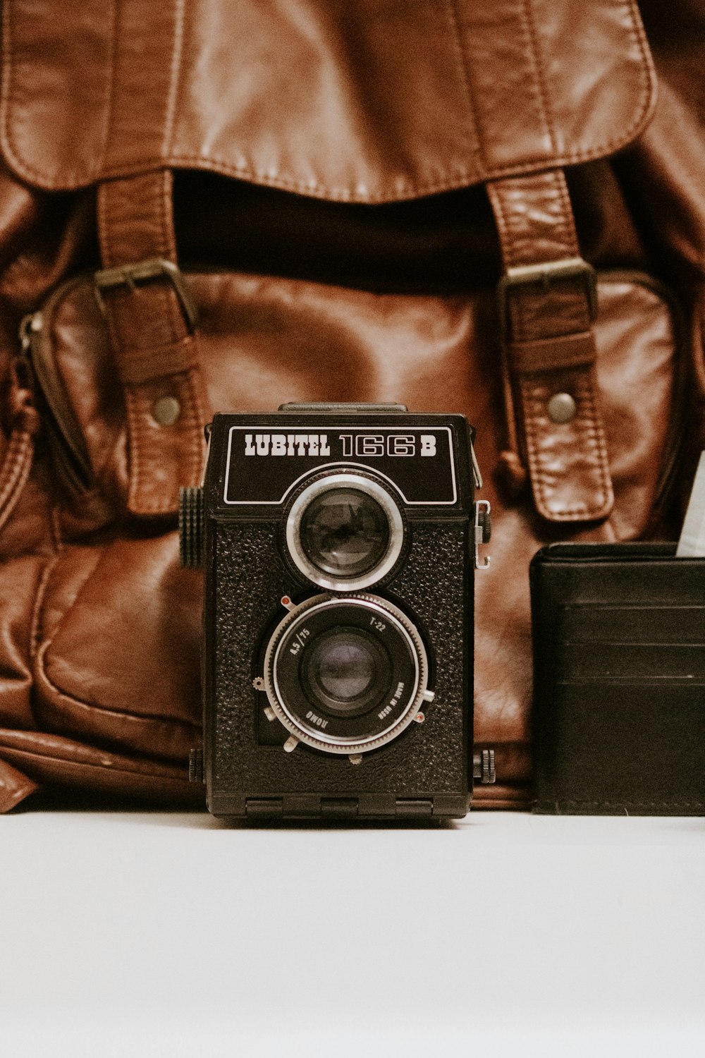 câmera Lubitel preta e bolsa de couro marrom