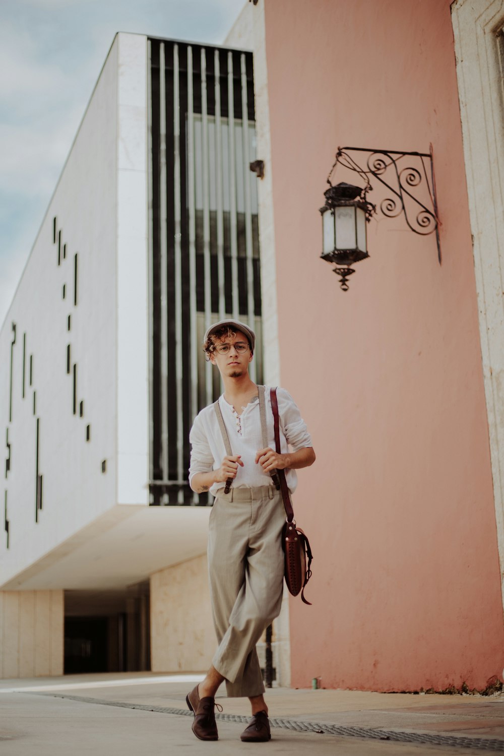 man standing while holding his suspenders