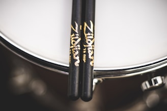 A close-up of drumsticks on a drum set.