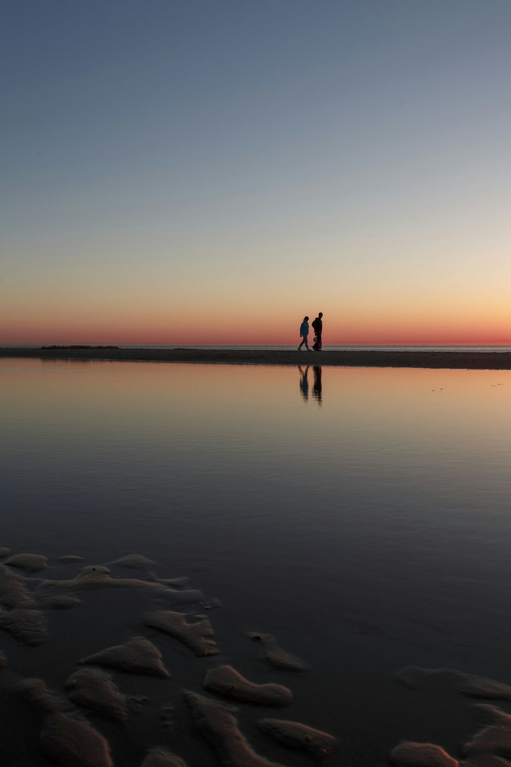 due persone in piedi sul molo della spiaggia