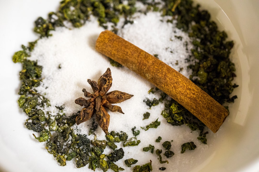 star anise and cinnamon in bowl along with green herbs and white crystal