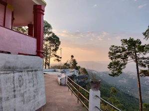 Guests relaxing on a balcony overlooking the sunrise over Mukteshwar’s mountain valley.