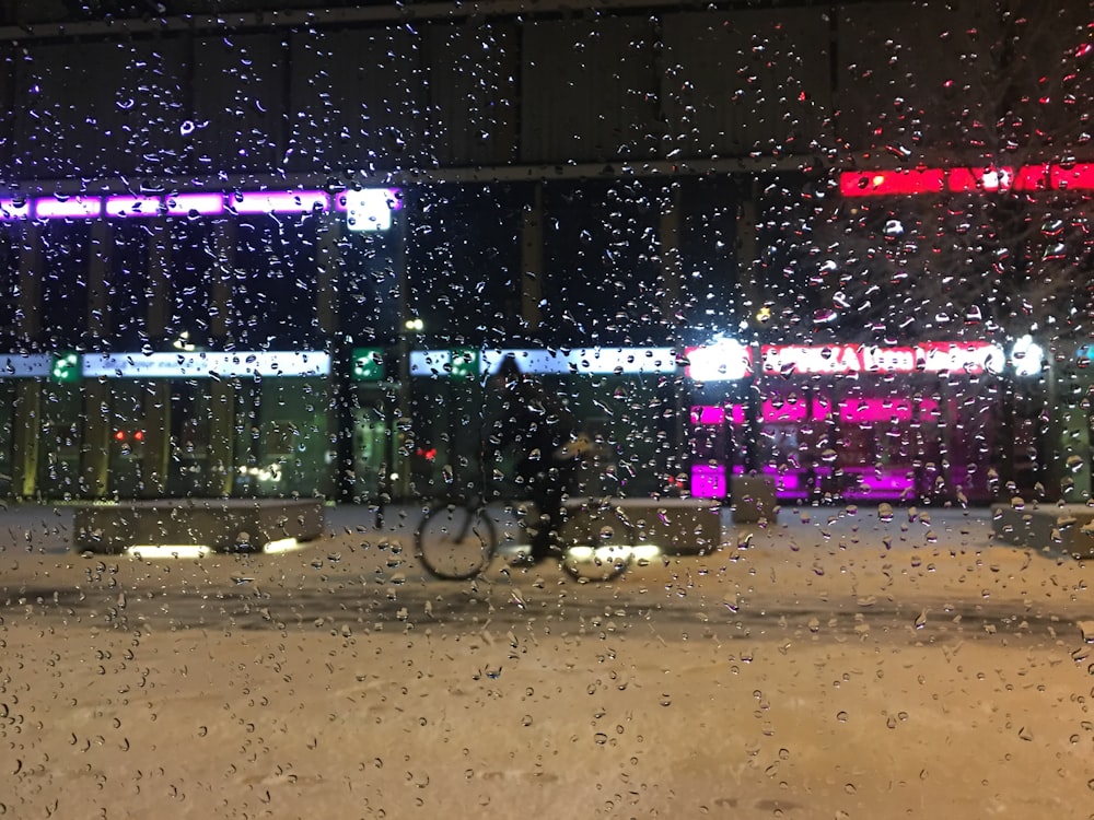 man riding bike on snow covered road at night time