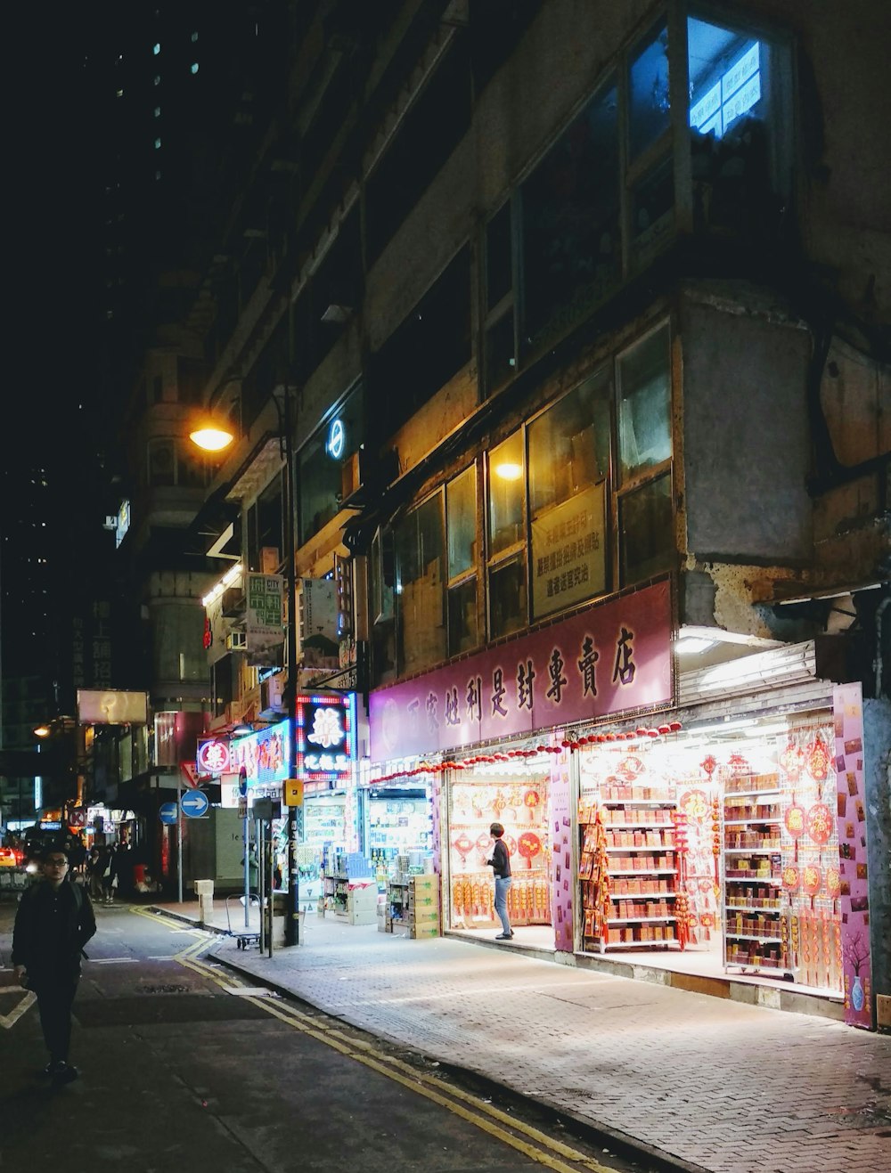 person standing on pink concrete building at night