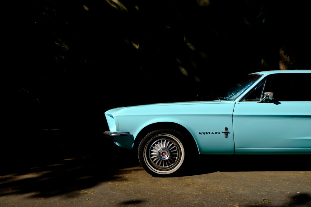 teal classic Ford Mustang parked on side of road