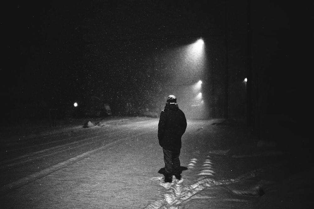 grayscale photography of man standing on street