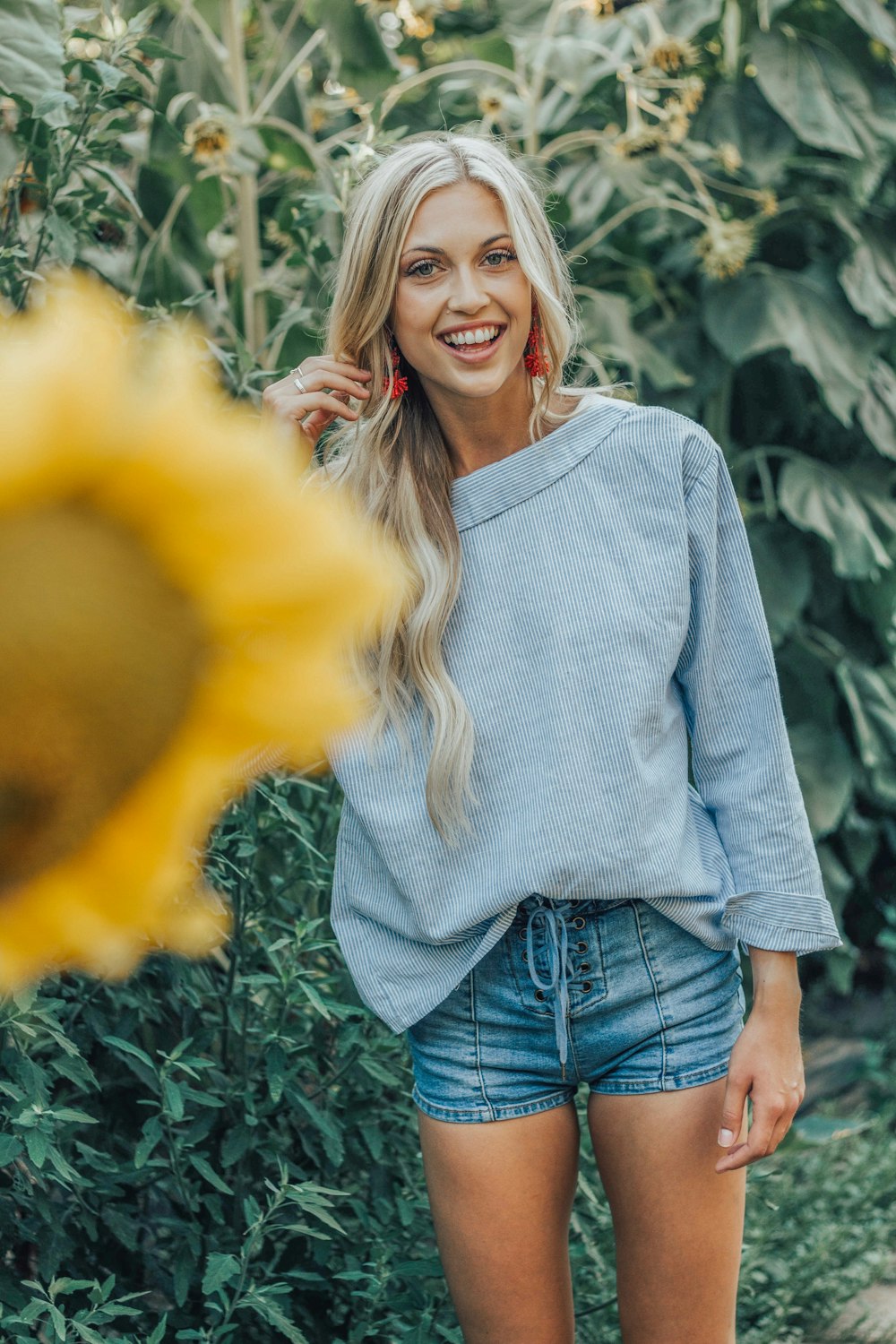 woman standing beside sunflower plant