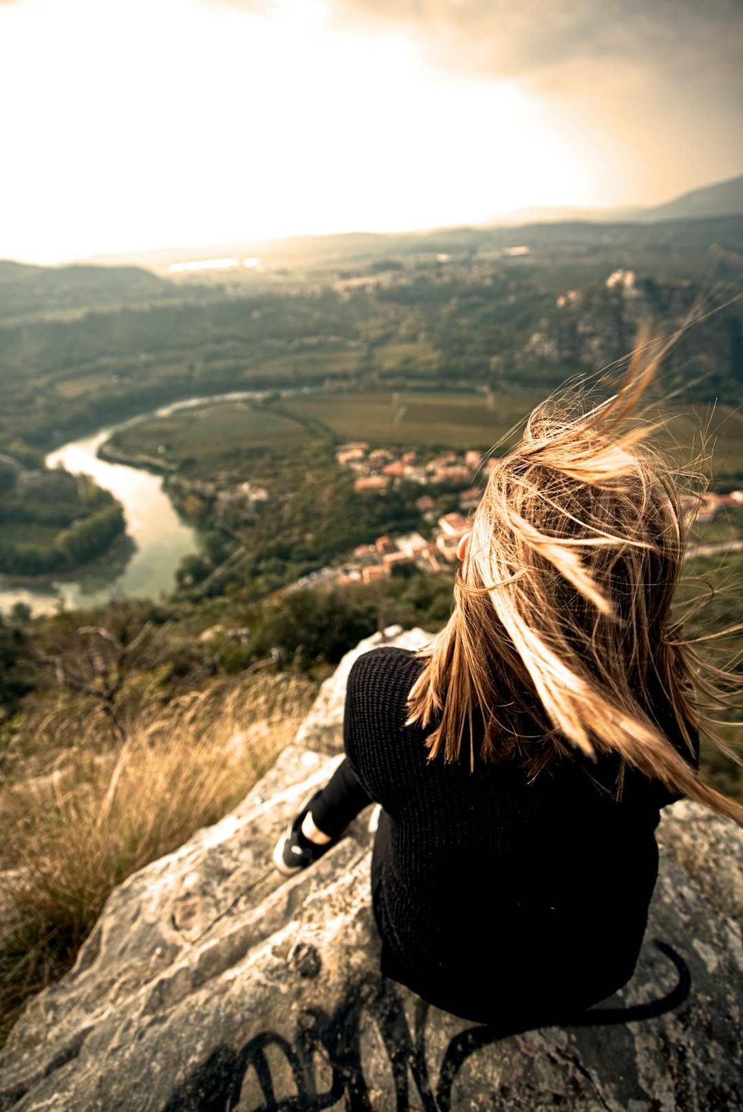 woman sitting on rock during daytime