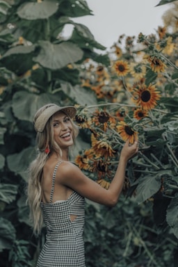 photography poses for women,how to photograph stop and smell the (sunflowers); one unknown celebrity smiling while holding sunflower