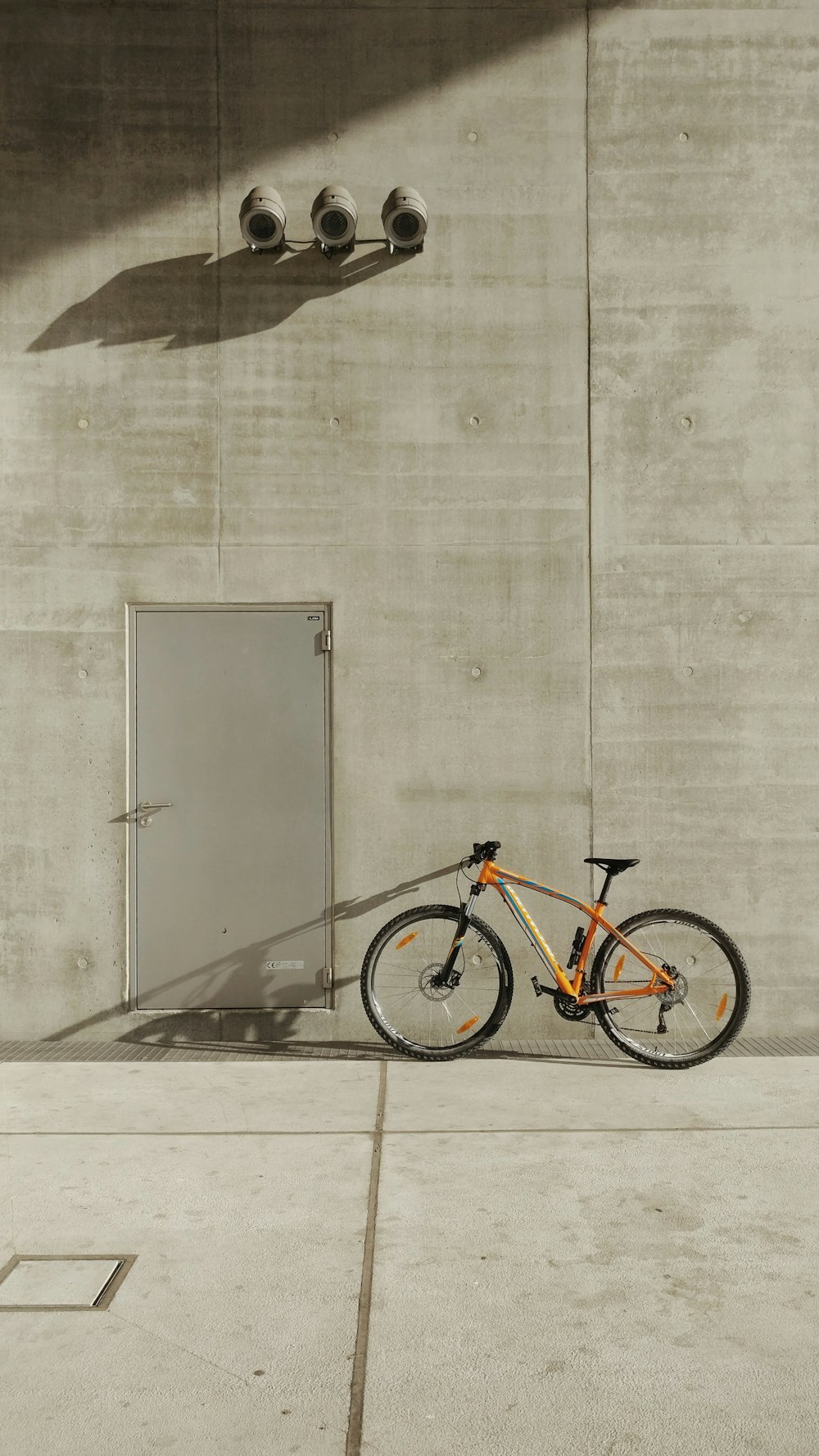 Bicicleta de montaña naranja al lado de la pared