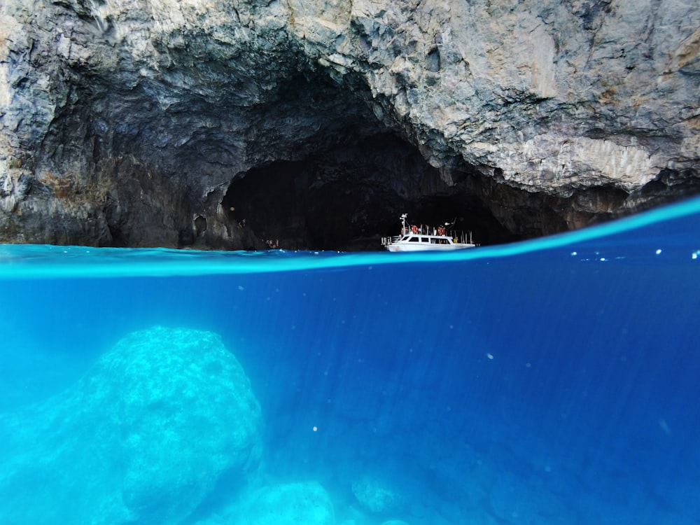 barca bianca che naviga vicino alla grotta durante il giorno