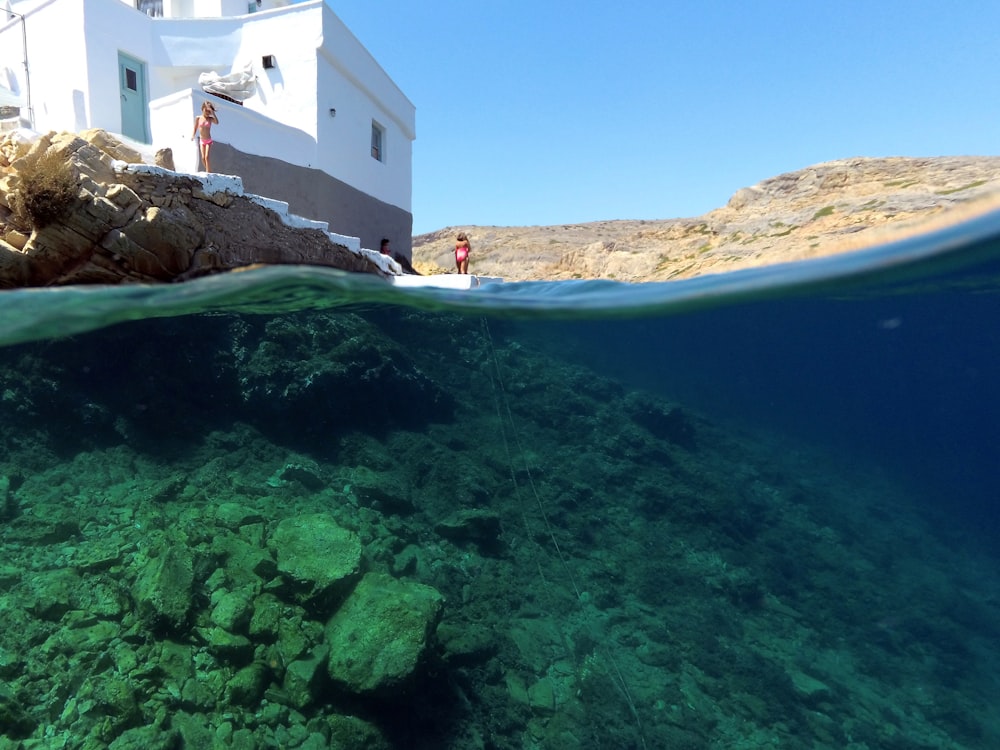 Persona in piedi vicino all'edificio accanto allo specchio d'acqua