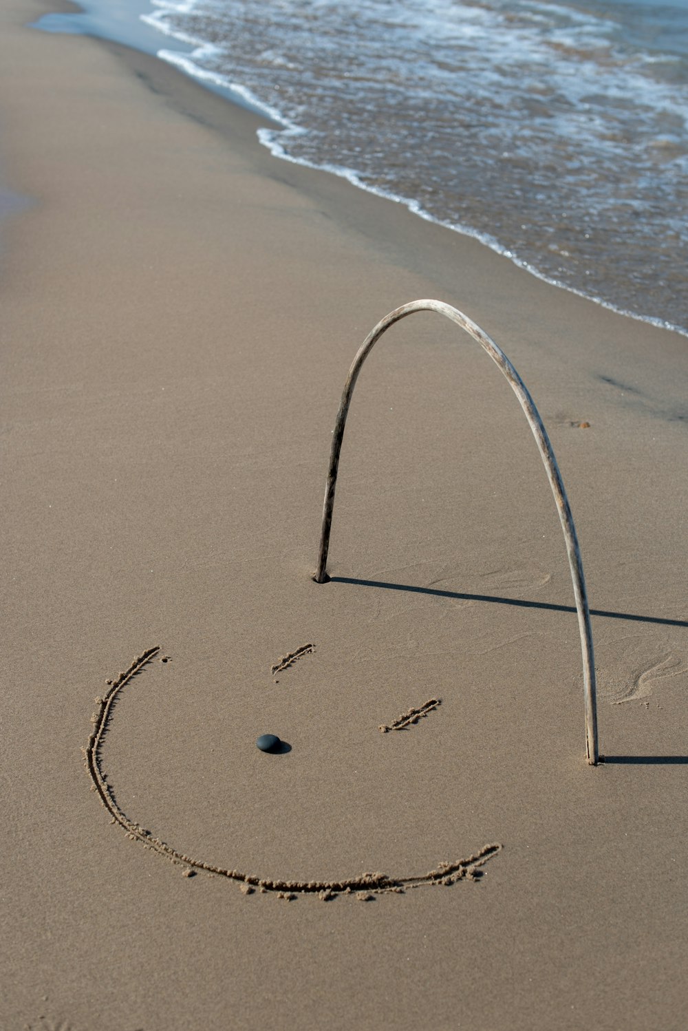 grey stick forming u letter on the seashore