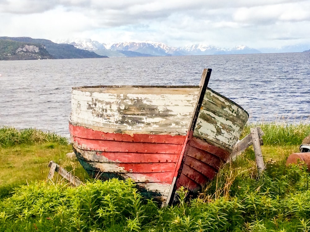 red and white wooden boat in beach