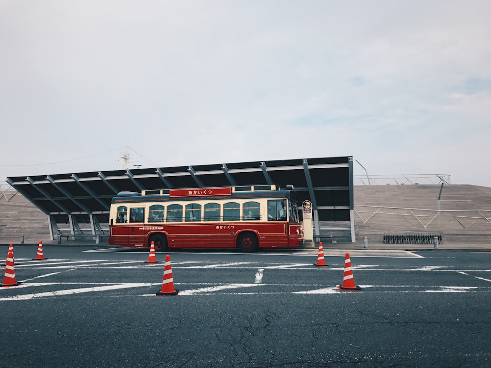 Ônibus vermelho e bege estacionado na rua
